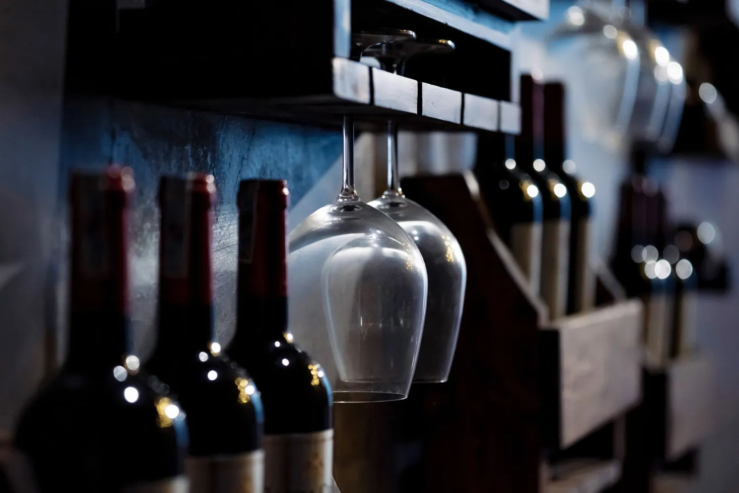 Taças e garrafas de vinho em uma adega